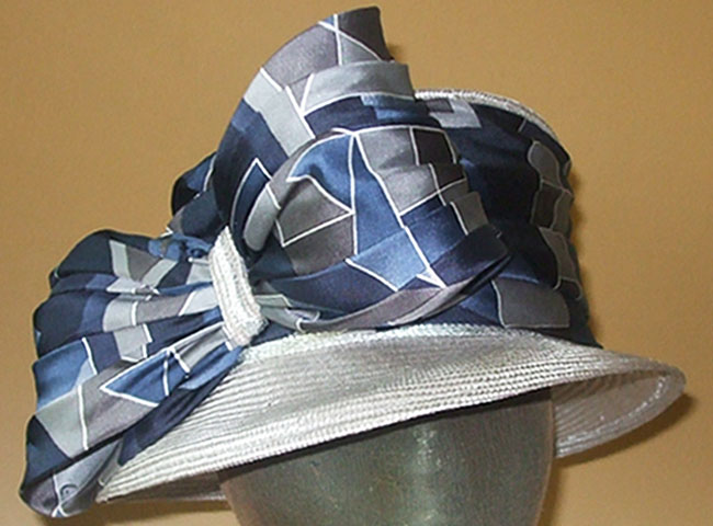 A medium brim with crown wrapped in patterned satin with oversized matching bow.