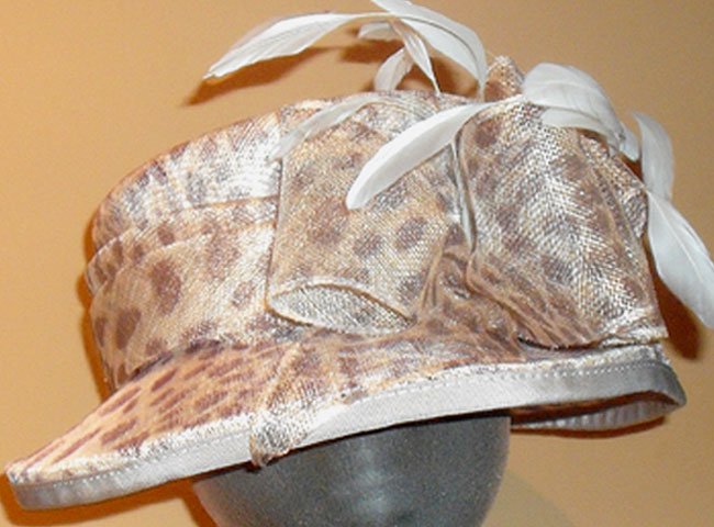 Medium sized sinamay, a small turned-down brim with large double bow and feathers.