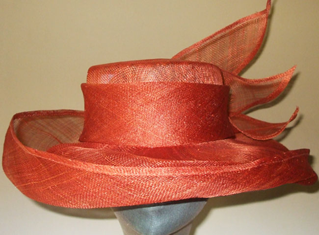 A sinamay hat with a wrap-around, upturned brim and with swoosh trimix the back.